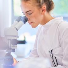 Female student looking through a microscope